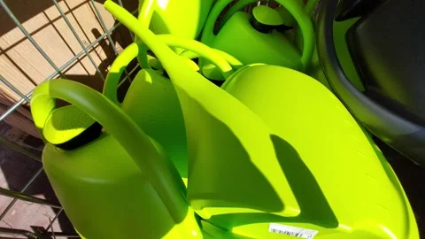 Stack of bright green plastic watering cans in a garden center Stock Footage 333643339
