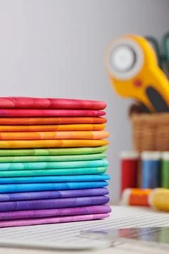 Stack of bright multicolored fabrics, accessories for sewing and quilting Stock-Fotos