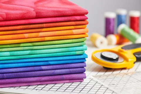 Stack of bright multicolored fabrics, accessories for sewing and quilting Fotos de archivo