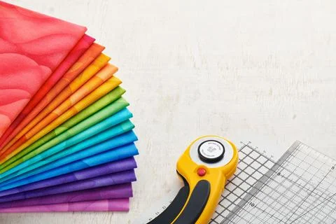 Stack of bright multicolored fabrics, accessories for quilting. Space for tex Stock Photos