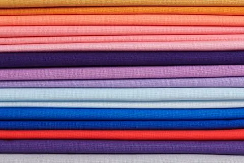 Stack of bright self-colored cotton fabrics as a background image 库存照片