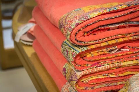 A stack of bright towels with original ornaments. Textile. Bath accessories. Stock Photos