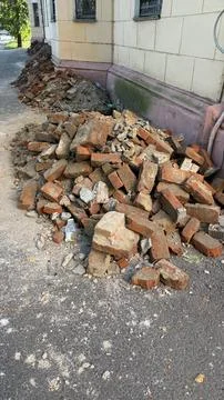 Stack of broken bricks and rubble on a street next to a building corner 写真素材