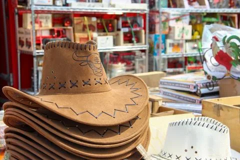 A stack of brown and white cowboy hats sitting on a table in a store.. The .. Stock-Fotos