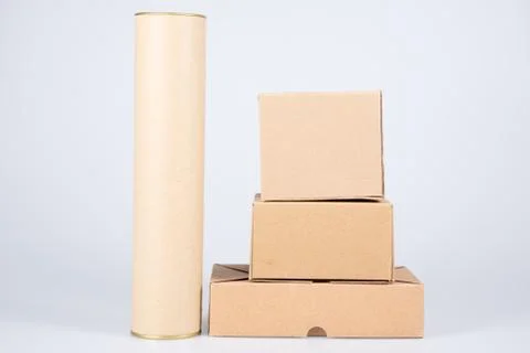 Stack of brown cardboard boxes with card board tube on white background Stock Photos