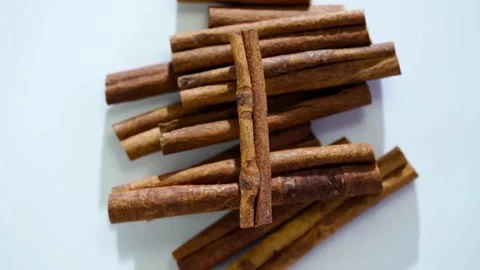Stack of brown cinnamon sticks on white plain background Video stock 333809120