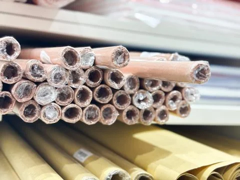 Stack of brown decorative paper rolls on a shelf in a craft store Stock Photos