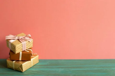 Stack of brown gift boxes on green wooden table. pink wall background 写真素材