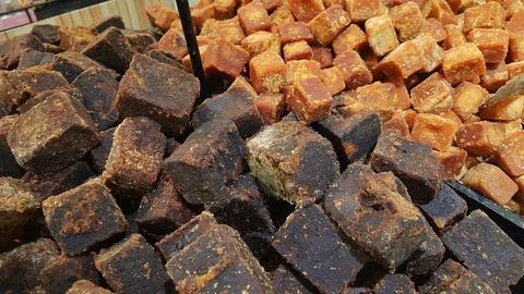 A stack of brown palm sugar cubes or gula merah for sale at supermarket Stock Photos