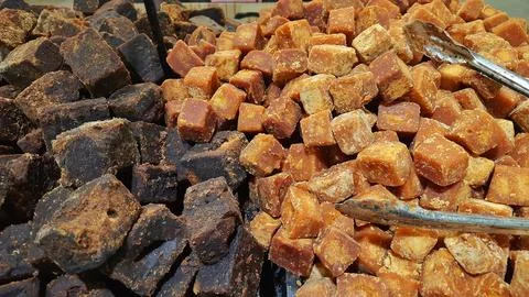 A stack of brown palm sugar cubes or gula merah for sale at supermarket Stock Photos