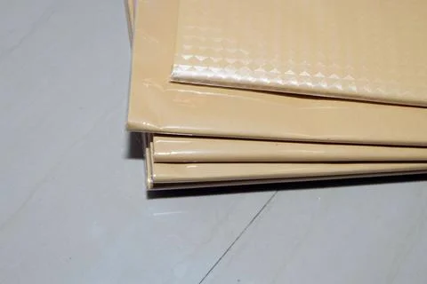 A stack of brown paper covers or packages embossed with a diamond pattern, .. Stockfoto's