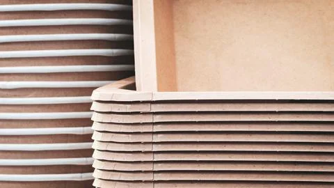 A stack of brown recycled cardboard boxes with a white box in the middle. The Stock Photos
