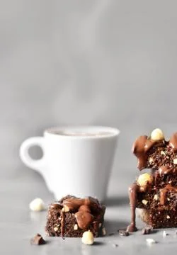 Stack of a brownie pieces and cup on a grey table with gray background. Stock Photos