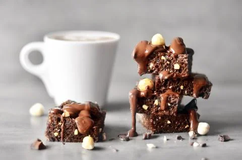 Stack of a brownie pieces and cup on a grey table with gray background. Foto stock