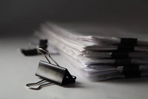 Stack of business papers with binder clips on gray background. Selective focu Stock Photos
