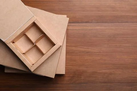 Stack of candy boxes on wooden background, top view. Space for text Stockfoto's