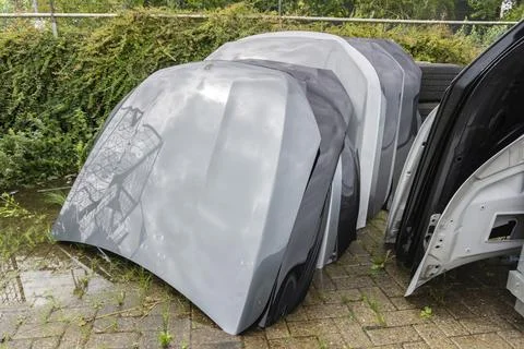 Stack of car hoods damaged by hail stored outdoors for repair or recycling Stock Photos