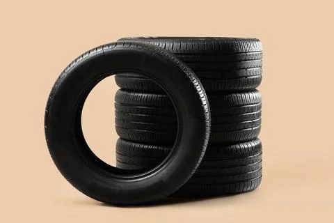 Stack of car tires on beige background Stock Photos