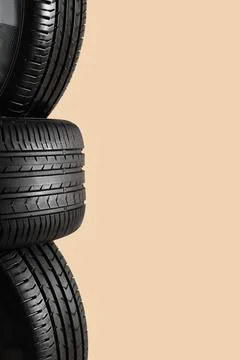 Stack of car tires on beige background, closeup Stock Photos