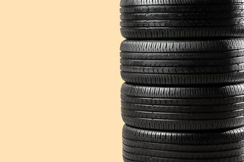 Stack of car tires on beige background Stock Photos