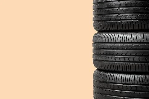 Stack of car tires on beige background, closeup Fotos de archivo