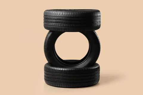 Stack of car tires on beige background Stock Photos
