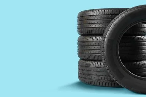 Stack of car tires on blue background Fotos de archivo