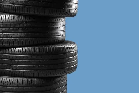 Stack of car tires on blue background, closeup Stock Photos