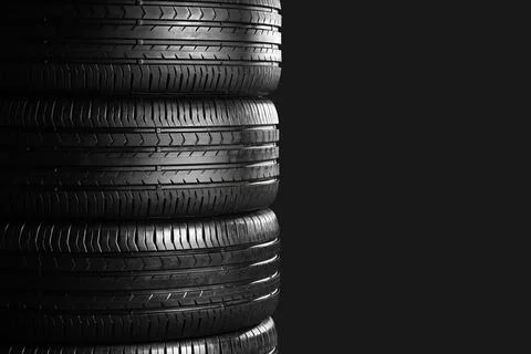 Stack of car tires on dark background, closeup Stock Photos