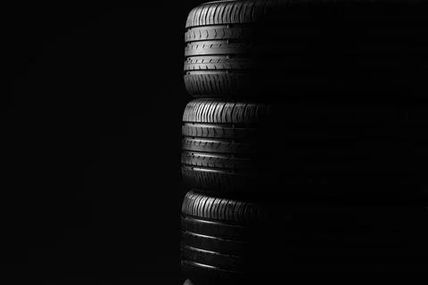 Stack of car tires on dark background Fotos de archivo
