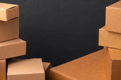 Stack of cardboard boxes against black background Foto stock