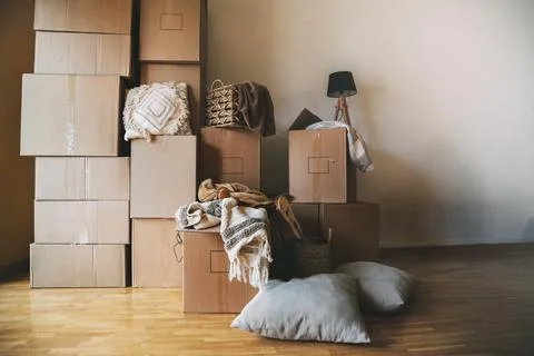 Stack of cardboard boxes and decorative house objects in new apartment. Movin Stock Photos