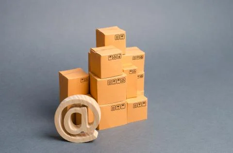 Stack of cardboard boxes and email symbol commercial AT. E-commerce. Internet Stock Photos
