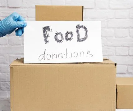 Stack of cardboard boxes and white sheet of paper with inscription food donat 스톡 사진