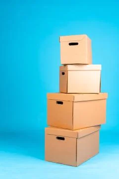 Stack of cardboard boxes on blue background Stock Photos