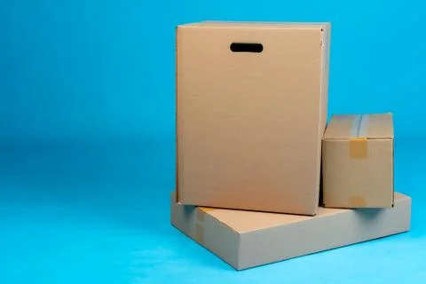 Stack of cardboard boxes on blue background Stock Photos