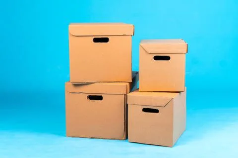 Stack of cardboard boxes on blue background Stock Photos