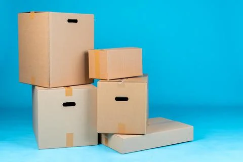Stack of cardboard boxes on blue background Stock Photos