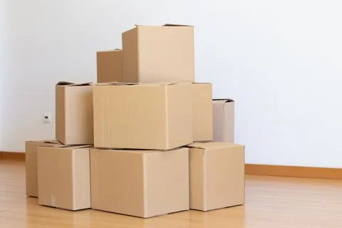 Stack of cardboard boxes in empty room Stock Photos