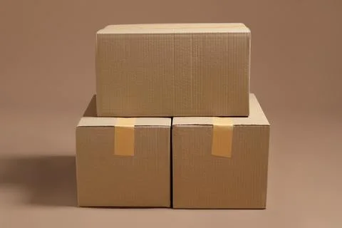 Stack of cardboard boxes on light brown background Stock Photos