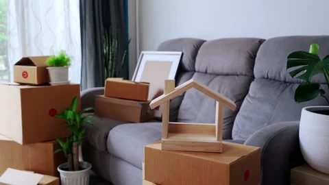 Stack of cardboard boxes in living room at new house on moving day Видео 137520953