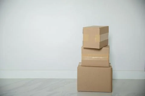 Stack of cardboard boxes for moving, Empty room with a white wall and cardboa Stock Photos