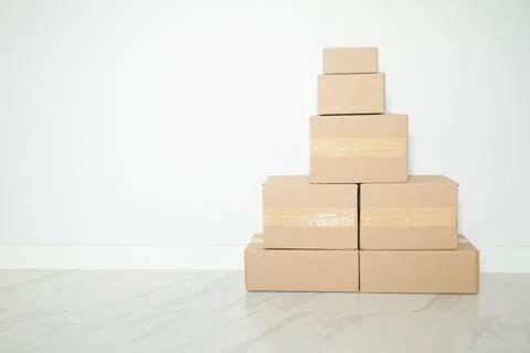 Stack of cardboard boxes for moving, Empty room with a white wall and cardboa Stock Photos