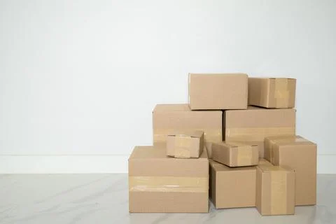 Stack of cardboard boxes for moving, Empty room with a white wall and cardboa Stock Photos