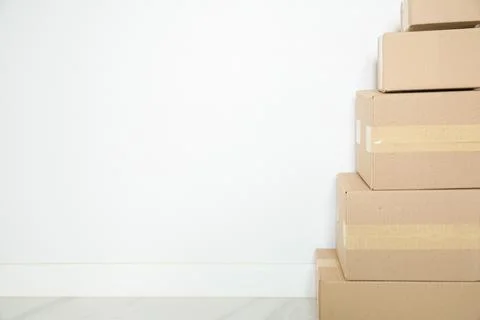Stack of cardboard boxes for moving, Empty room with a white wall and cardboa Stock Photos