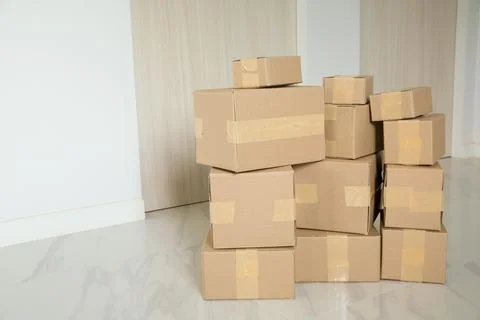 Stack of cardboard boxes for moving, Empty room with a white wall and cardboa Stock Photos