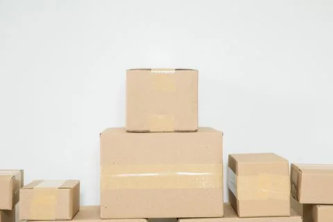 Stack of cardboard boxes for moving, Empty room with a white wall and cardboa 스톡 사진