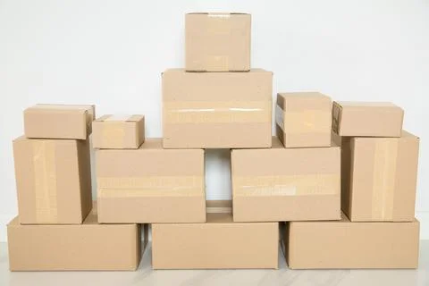 Stack of cardboard boxes for moving, Empty room with a white wall and cardboa 스톡 사진