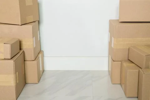 Stack of cardboard boxes for moving, Empty room with a white wall and cardboa Stock Photos
