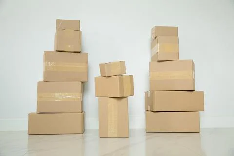Stack of cardboard boxes for moving, Empty room with a white wall and cardboa 写真素材